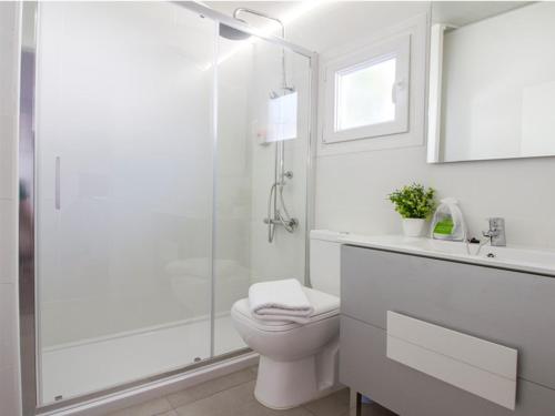 a white bathroom with a shower and a toilet at Alannia Guardamar in Guardamar del Segura