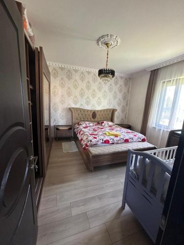 a bedroom with a bed and a chandelier at mado house in Chakvi