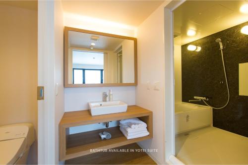 a bathroom with a sink and a mirror at Always Niseko in Kutchan