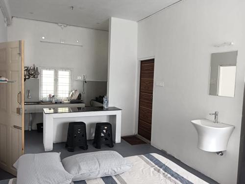 a white bathroom with a sink and a desk at Casa De Campo in Idukki