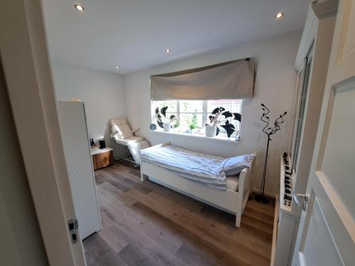 a small bedroom with a bed and a window at Villa shared Fieldsight Doornspijk - a shared villa no breakfast in Doornspijk