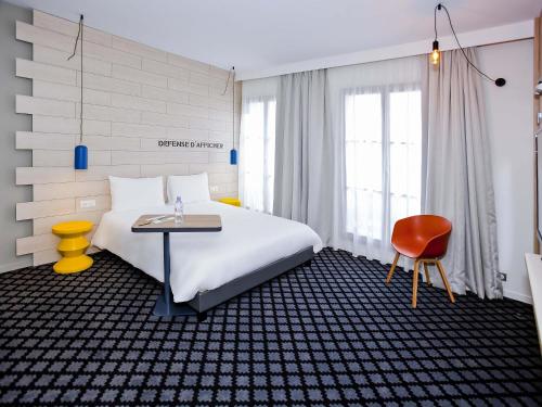 a bedroom with a bed and a table and a chair at ibis Styles Chalons en Champagne Centre in Chalons en Champagne