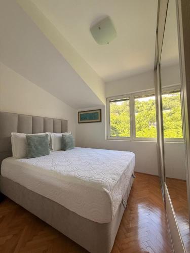 a bedroom with a large bed with two windows at Lovely duplex apartment in Savina