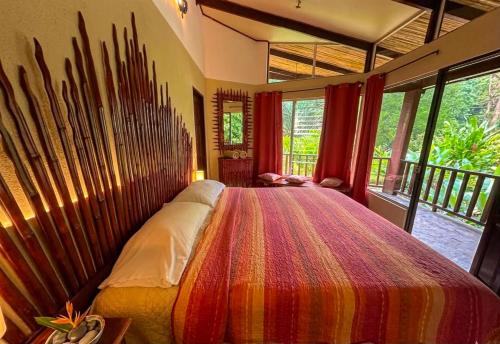 a bedroom with a large bed with a colorful blanket at Heliconia Island Lodge in Puerto Viejo