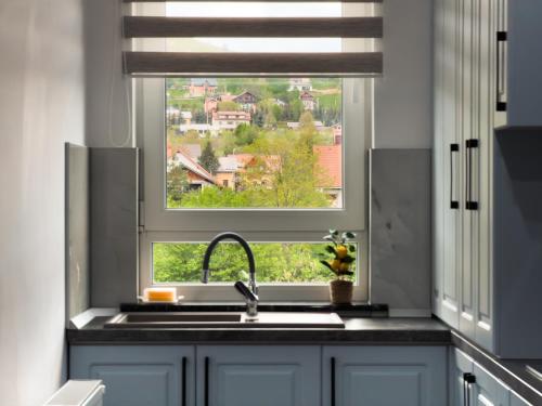 a kitchen with a sink and a window with a view at Bucovina Comfort Apartament in Gura Humorului