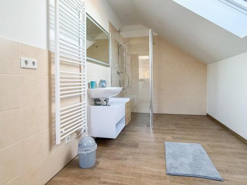 a bathroom with a sink and a glass shower at Kraatzer Ferienwohnungen in Gransee