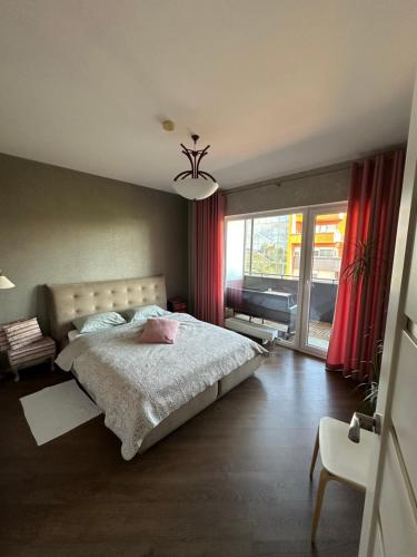 a bedroom with a bed and a large window at Apartament Birutes 22 in Klaipėda