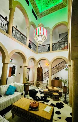 a large living room with a couch and a chandelier at Riad Aïcha Addi Pool & Hammam in Essaouira