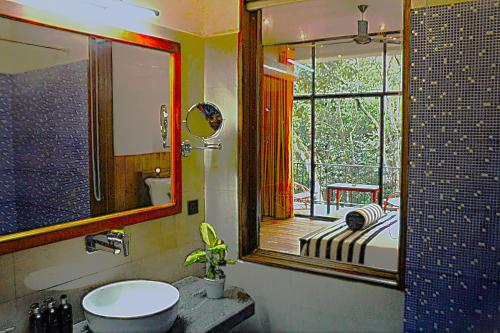 a bathroom with a sink and a mirror and a window at Green cottage Ella in Ella