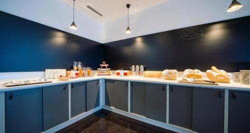 a kitchen with blue cabinets and white counter tops at PLAZA INN Salzburg Messe in Salzburg
