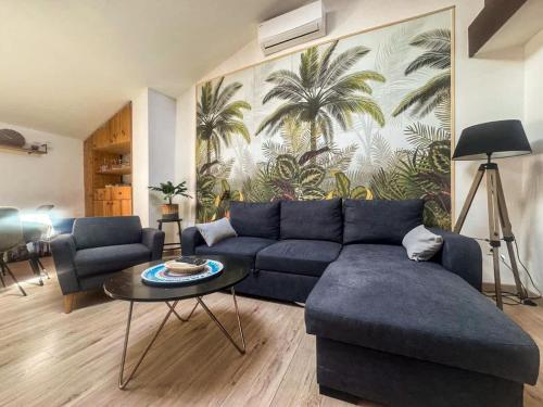 a living room with a blue couch and a table at The globe trotter - Perpignan in Perpignan