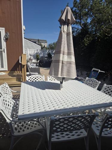 a picnic table with an umbrella and chairs at Seascape in Haven Beach