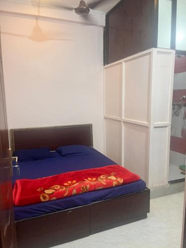 a bedroom with a bed with a red blanket on it at Himalayan Wellness Retreat in Rishīkesh