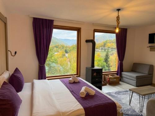 a bedroom with a bed and a large window at Hotel Chalet Kujta in Peje