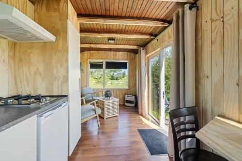 a kitchen and living room with wood paneling at Camping de Wartenster - De Pipowagen in Wartena