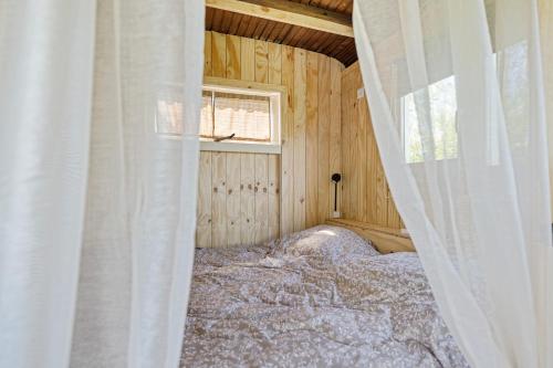 a bedroom with a bed in a wooden house at Camping de Wartenster - De Pipowagen in Wartena
