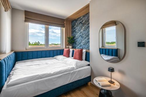 a small bedroom with a bed and a mirror at Lazuli Apartment in Hegykő