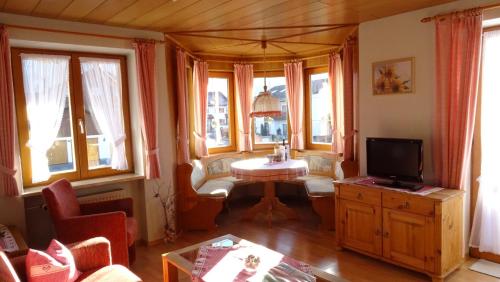 a living room with a tv and some windows at Gästehaus Annabell in Nesselwang