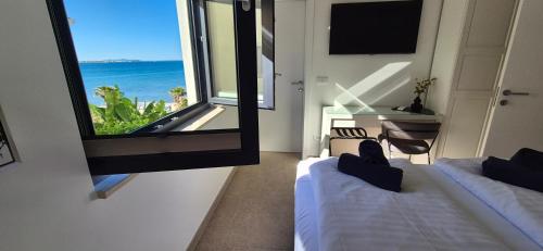 a room with two beds and a window with the ocean at Dinary Deluxe Apartments in Vir