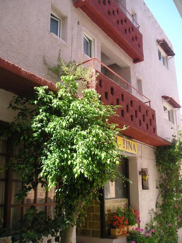 a building with a tree in front of it at Tina Hotel in Chania Town