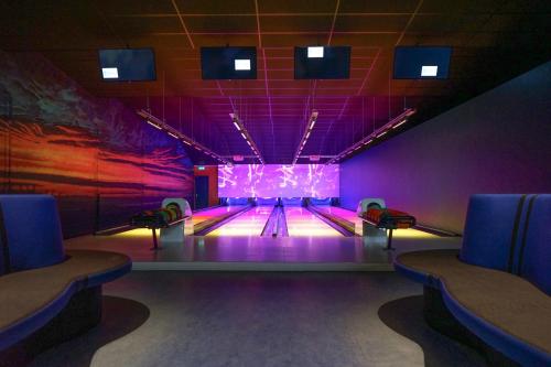 a bowling alley with lanes and purple lighting at EuroParcs Schoneveld in Breskens