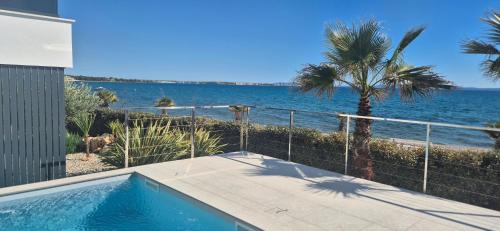 a swimming pool with a view of the ocean at Dinary Deluxe Apartments in Vir