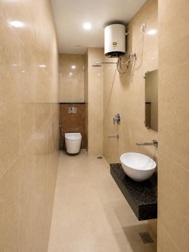 a bathroom with a sink and a toilet in it at Hotel Ram Sadan in Ayodhya