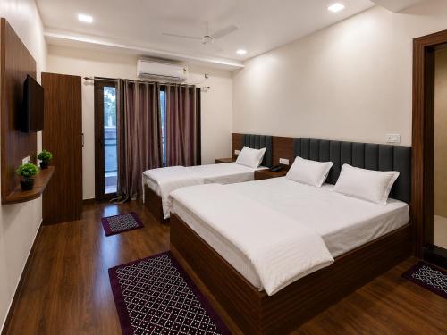 a hotel room with two beds and a television at Hotel Ram Sadan in Ayodhya