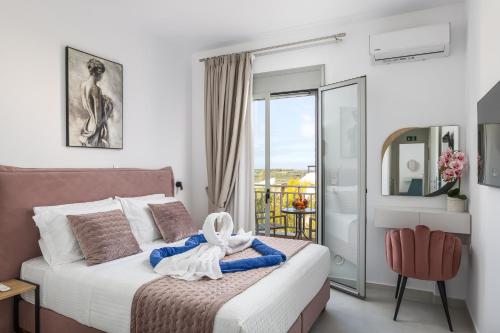 a bedroom with a bed and a chair and a window at Antonias Serenity in Loutra