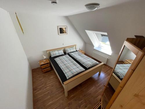 an attic bedroom with two beds and a window at Wattenmeer-Ferien in Süllwarden