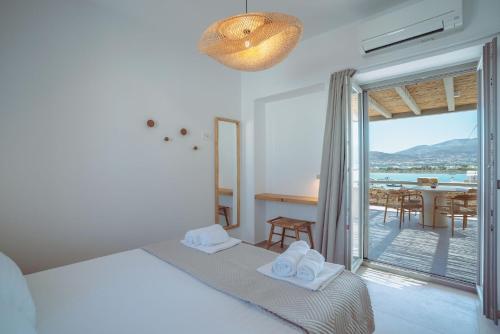 a bedroom with a bed and a balcony with a table at 5 Elements - Agapi's Houses in Antiparos
