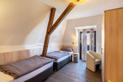 a room with two beds and a chair in it at Hotel Deitmer in Rhede