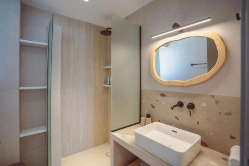 a bathroom with a sink and a mirror at 5 Elements - Agapi's Houses in Antiparos