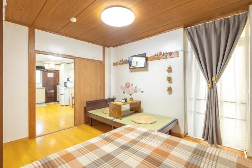 a bedroom with a bed and a table and a window at 大津屋a in Yokohama