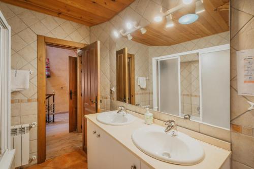 a bathroom with two sinks and a mirror at Sanz in Castro de Fuentidueña