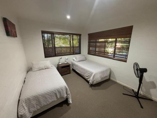 a bedroom with two beds and a window at Amaroo - Bring your own linen in Arakoon