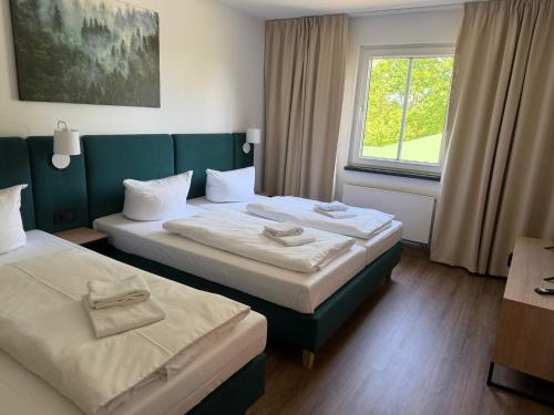 a hotel room with two beds and a window at ARC Hotel in Halle an der Saale