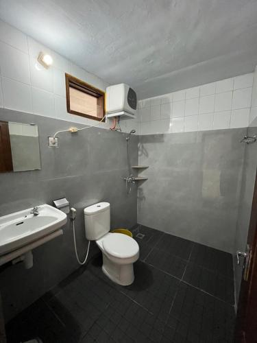 a bathroom with a toilet and a sink at Hotel Pison in Rantepao