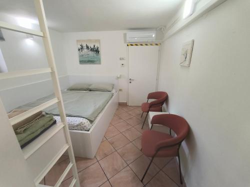 a bedroom with a bunk bed and two chairs at Love 2 Solkan in Nova Gorica