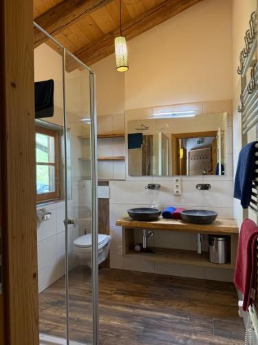 a bathroom with two sinks and a glass shower at Almhütte Eibingalm in Saalbach-Hinterglemm