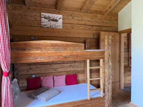 a bedroom with a bunk bed in a log cabin at Almhütte Eibingalm in Saalbach-Hinterglemm