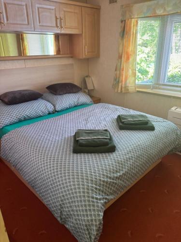 a bed with two green towels on top of it at Ubytování Levandule in Košín