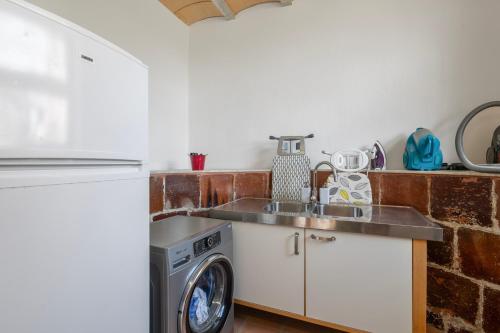 a kitchen with a sink and a washing machine at Villa de Lujo Cerca de Sitges in Sant Pere de Ribes
