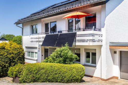 a house with an orange umbrella on the balcony at Gierske Ferienwohnung in Olsberg