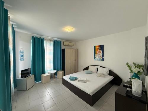a bedroom with a bed and a television in it at Hotel Zora by TM in Ravda