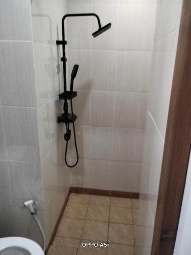 a bathroom with a shower with a toilet in it at Dalem Suwarno Baru in Timuran
