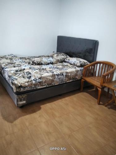 a bed and a wooden chair in a room at Dalem Suwarno Baru in Timuran