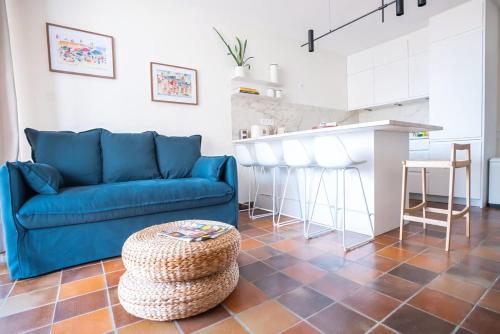 a living room with a blue couch and a table at La bulle canetoise - vue mer in Canet-en-Roussillon