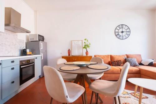 a living room with a couch and a table and chairs at Le Balcon Catalan - Perpignan Centre in Perpignan