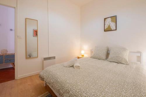 a white bedroom with a bed and a mirror at Le Balcon Catalan - Perpignan Centre in Perpignan